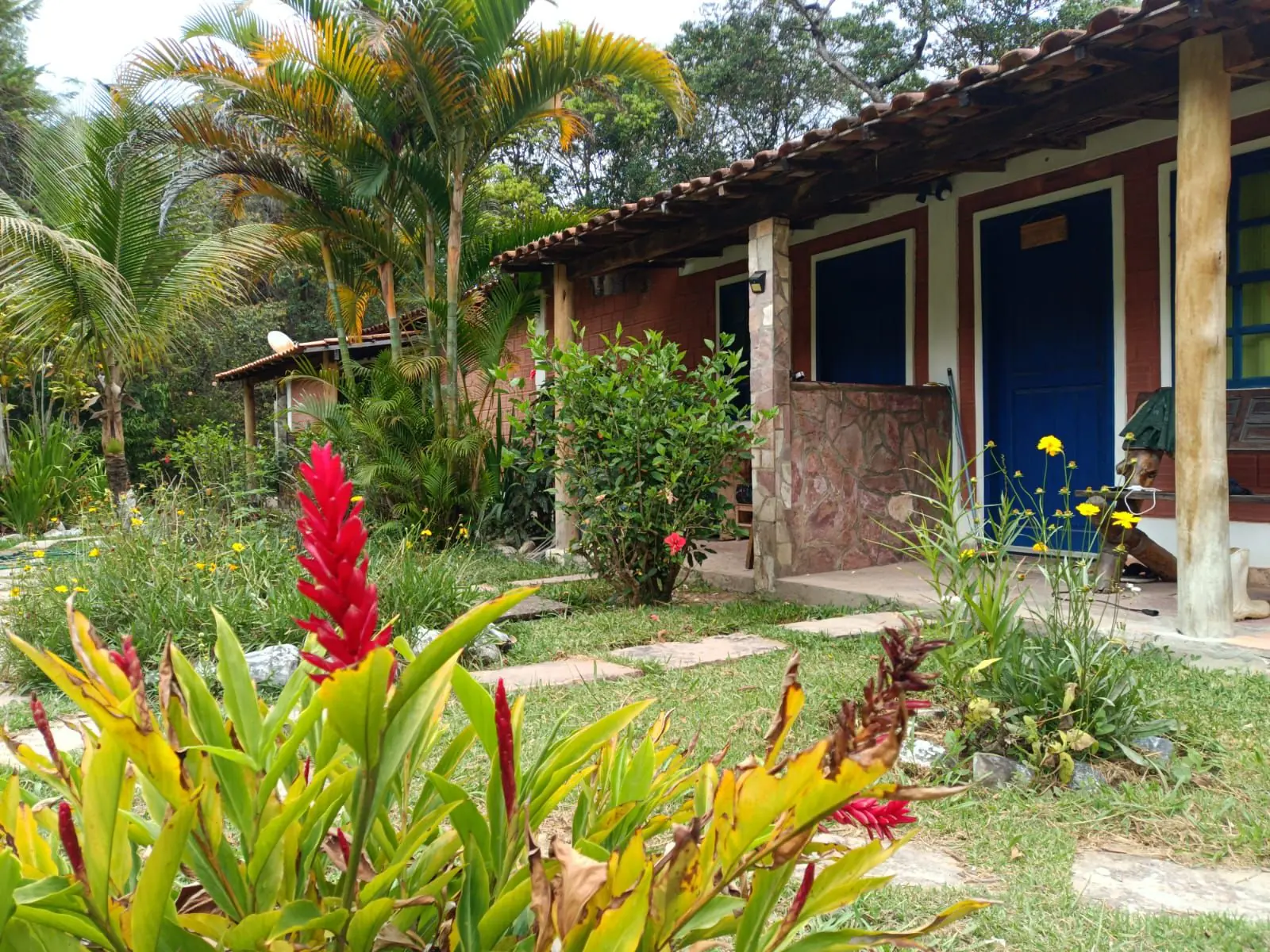 Jardim e construções rústicas da propriedade no Vale do Capão