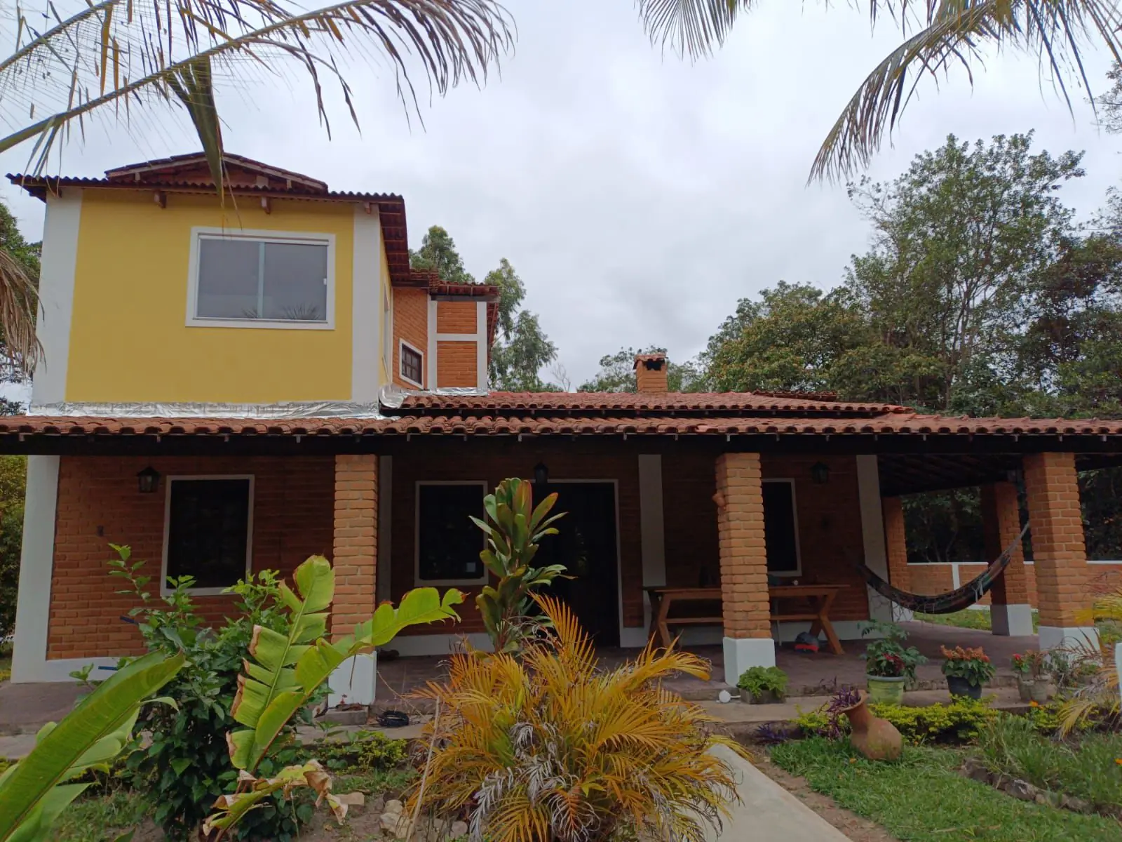 Casa de dois pavimentos cercada pela vegetação